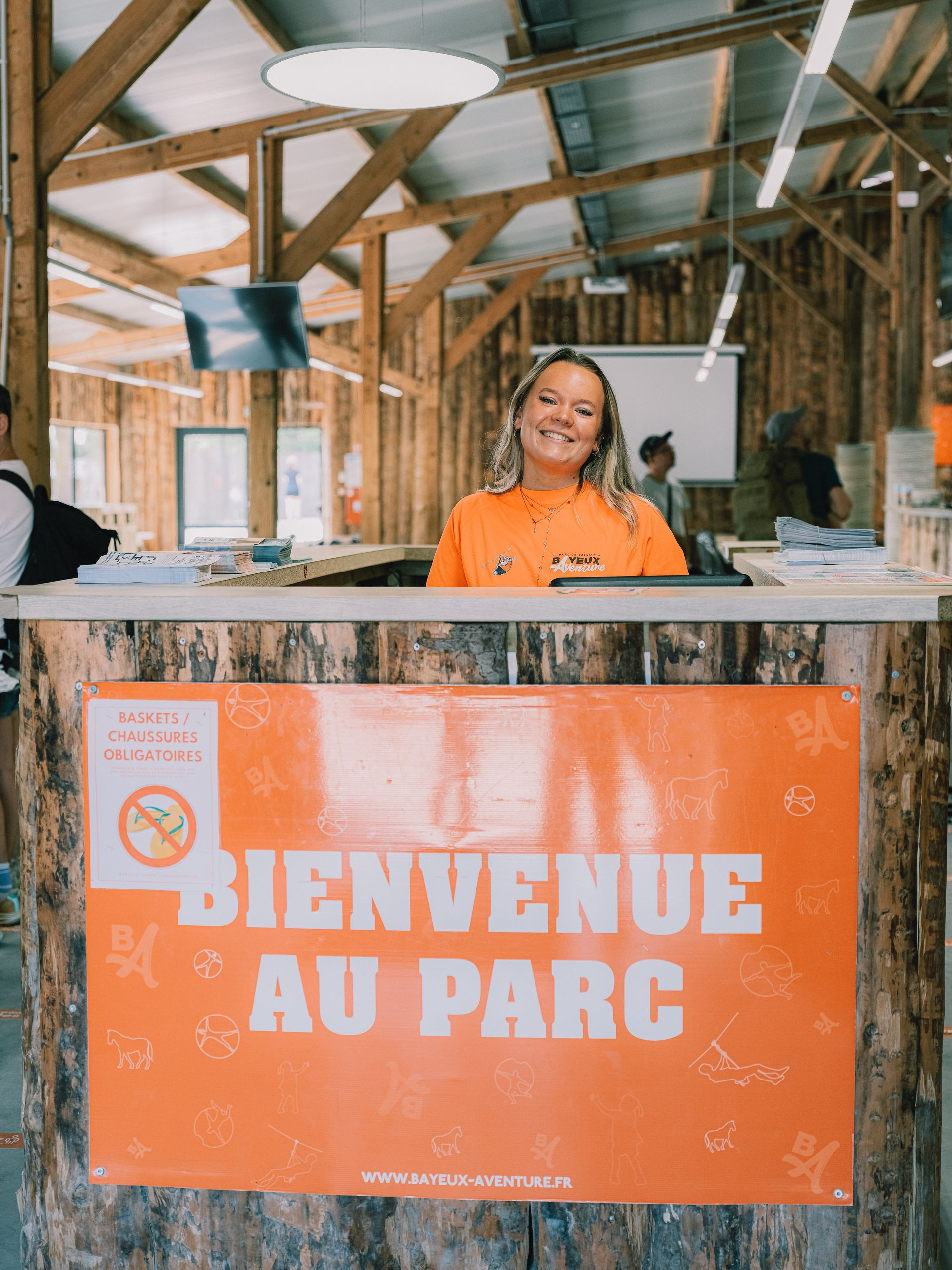 Une animatrice accueille les visiteurs derrière le comptoir « Bienvenue au parc »
