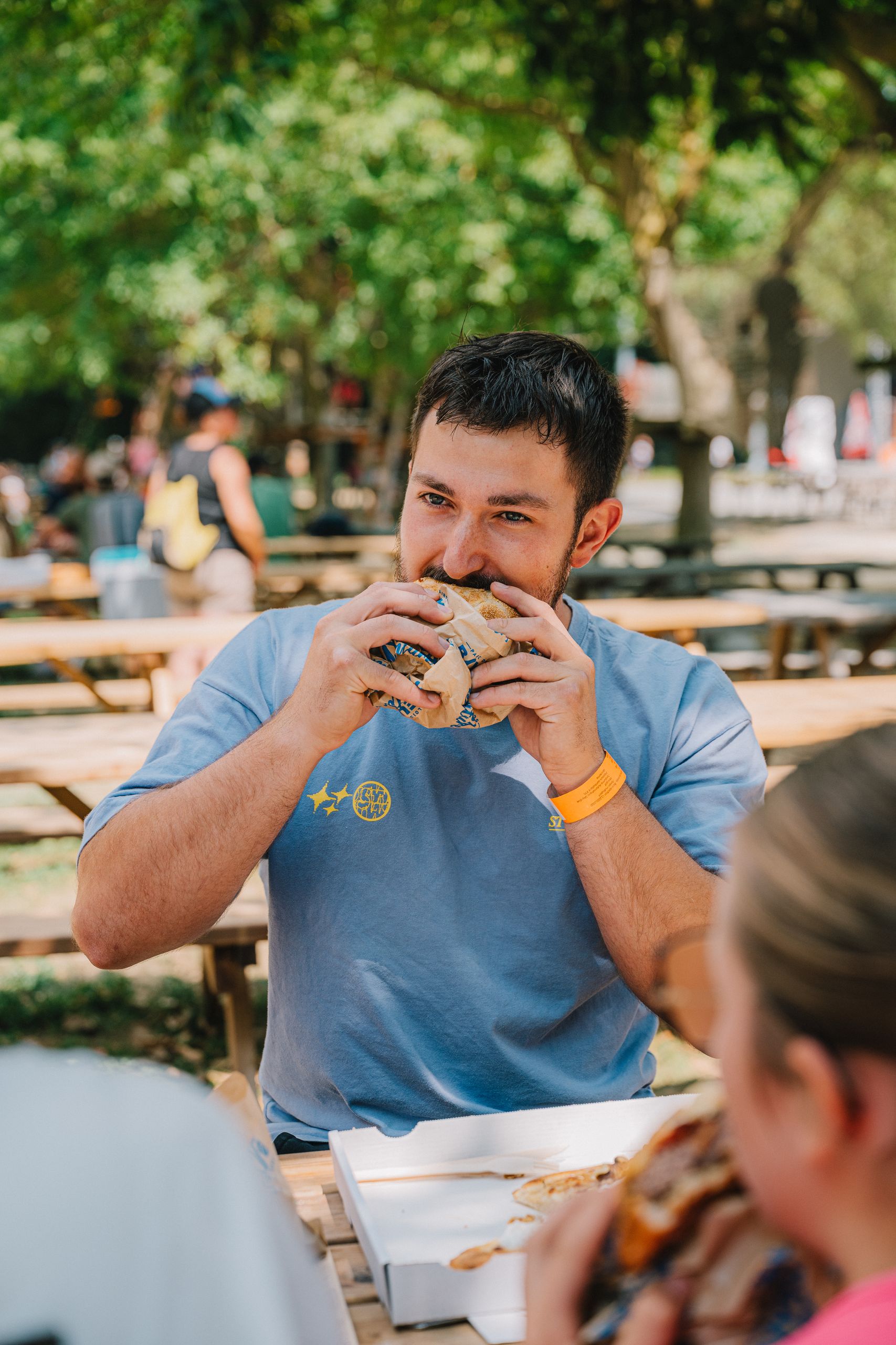Un visiteur déguste un burger sur l’espace pique-nique du parc