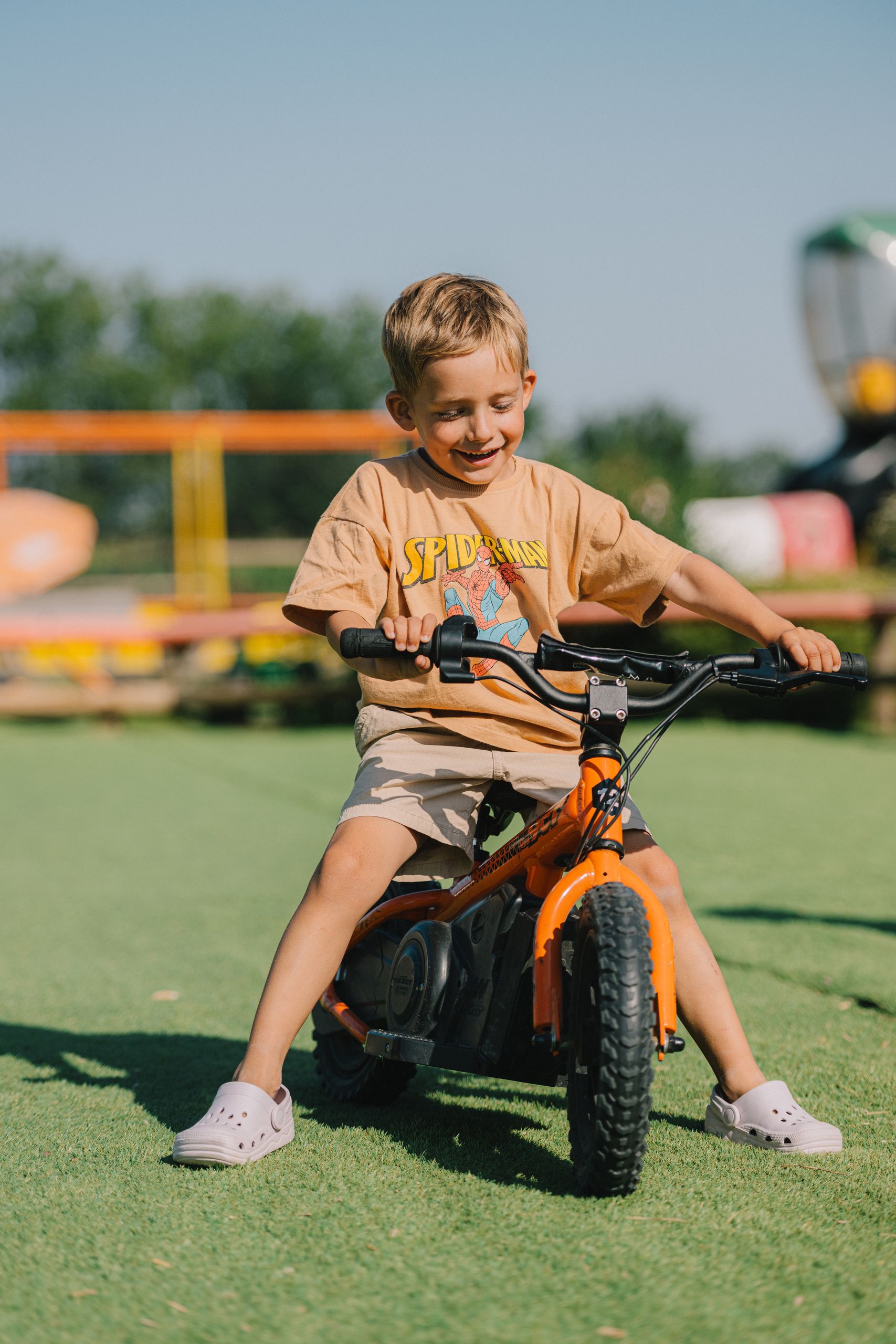 Un enfant souriant roule sur une draisienne électrique