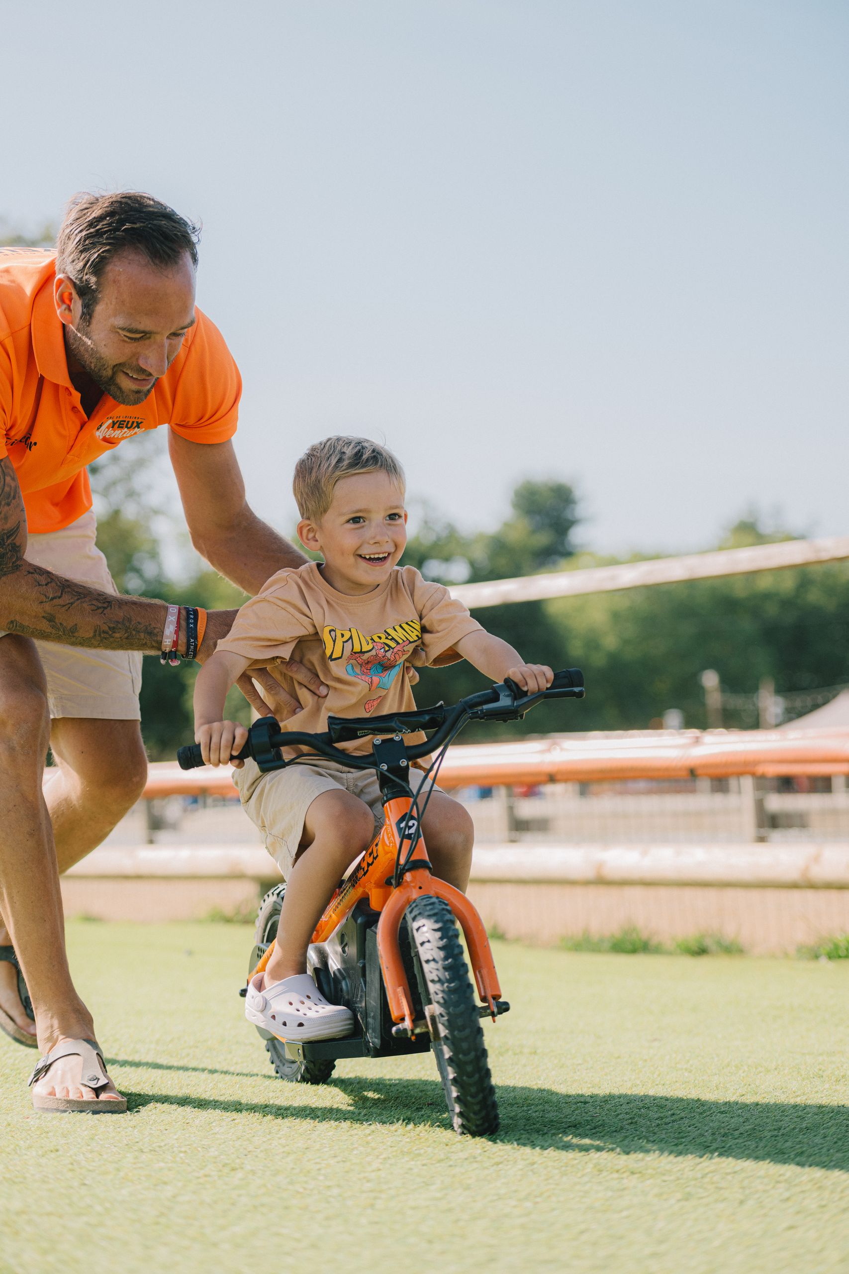 Un animateur accompagne un enfant sur une draisienne électrique