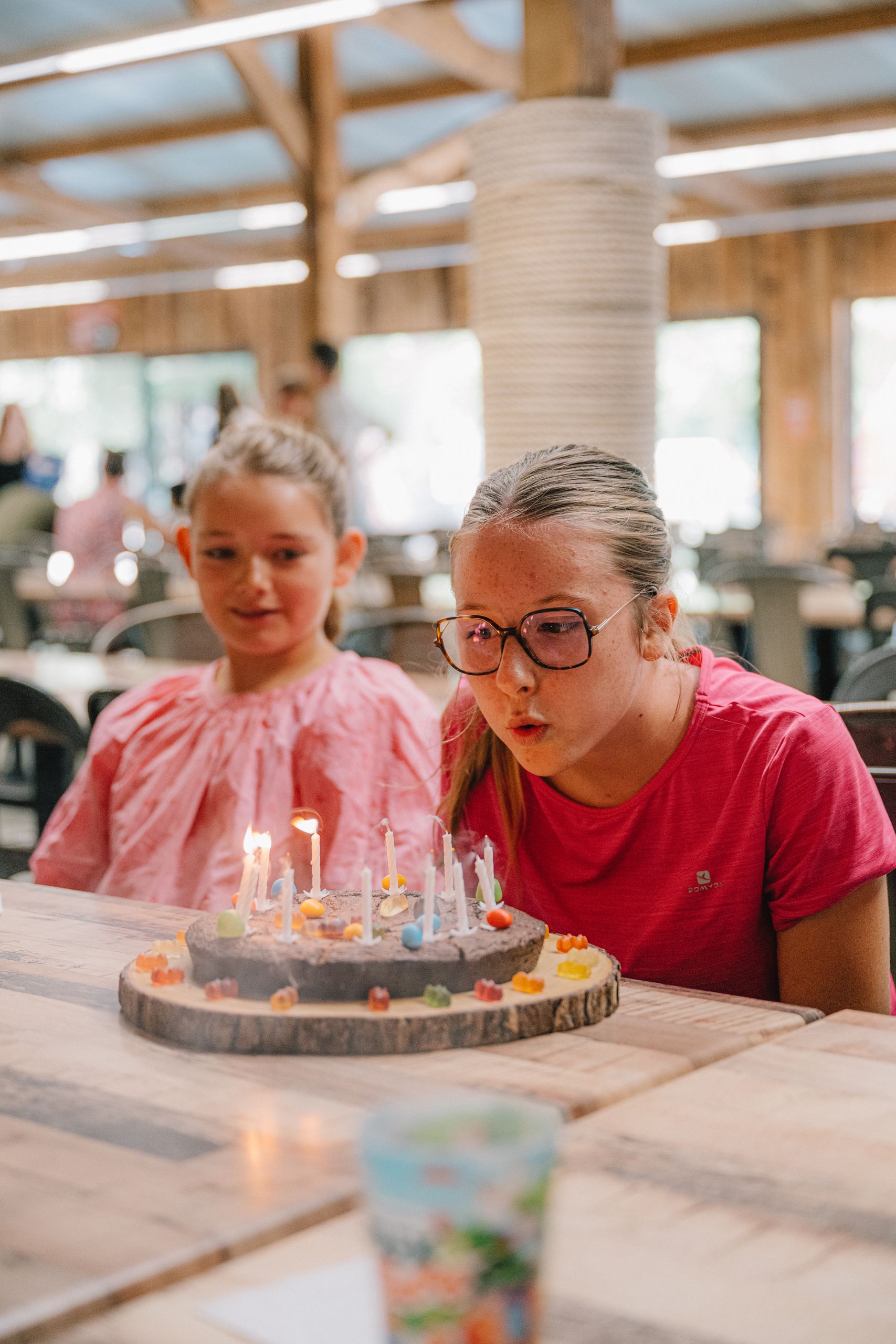 Une enfant souffle les bougies de son gâteau d'anniversaire