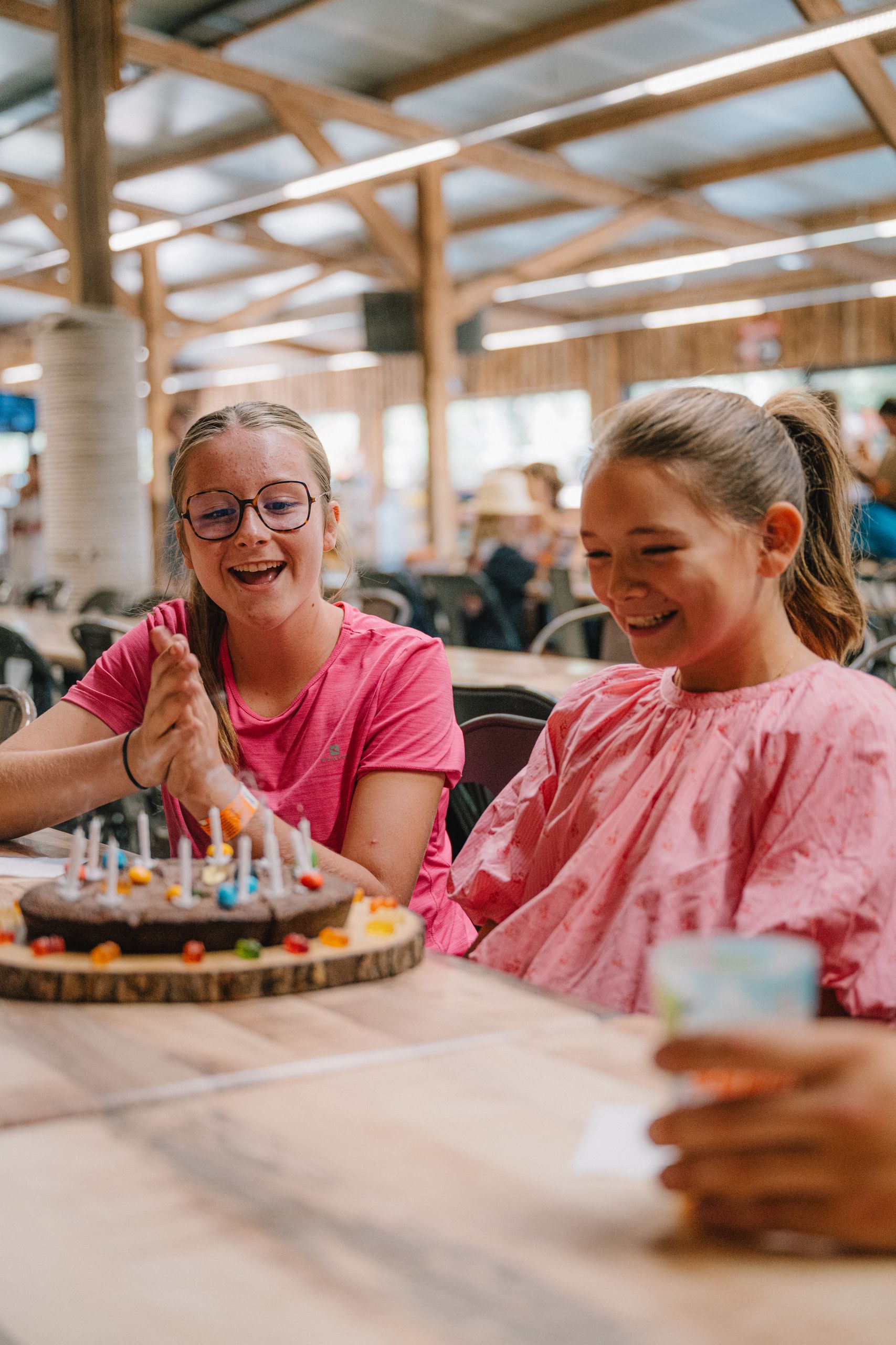 Deux enfants sourient devant le gâteau d'anniversaire