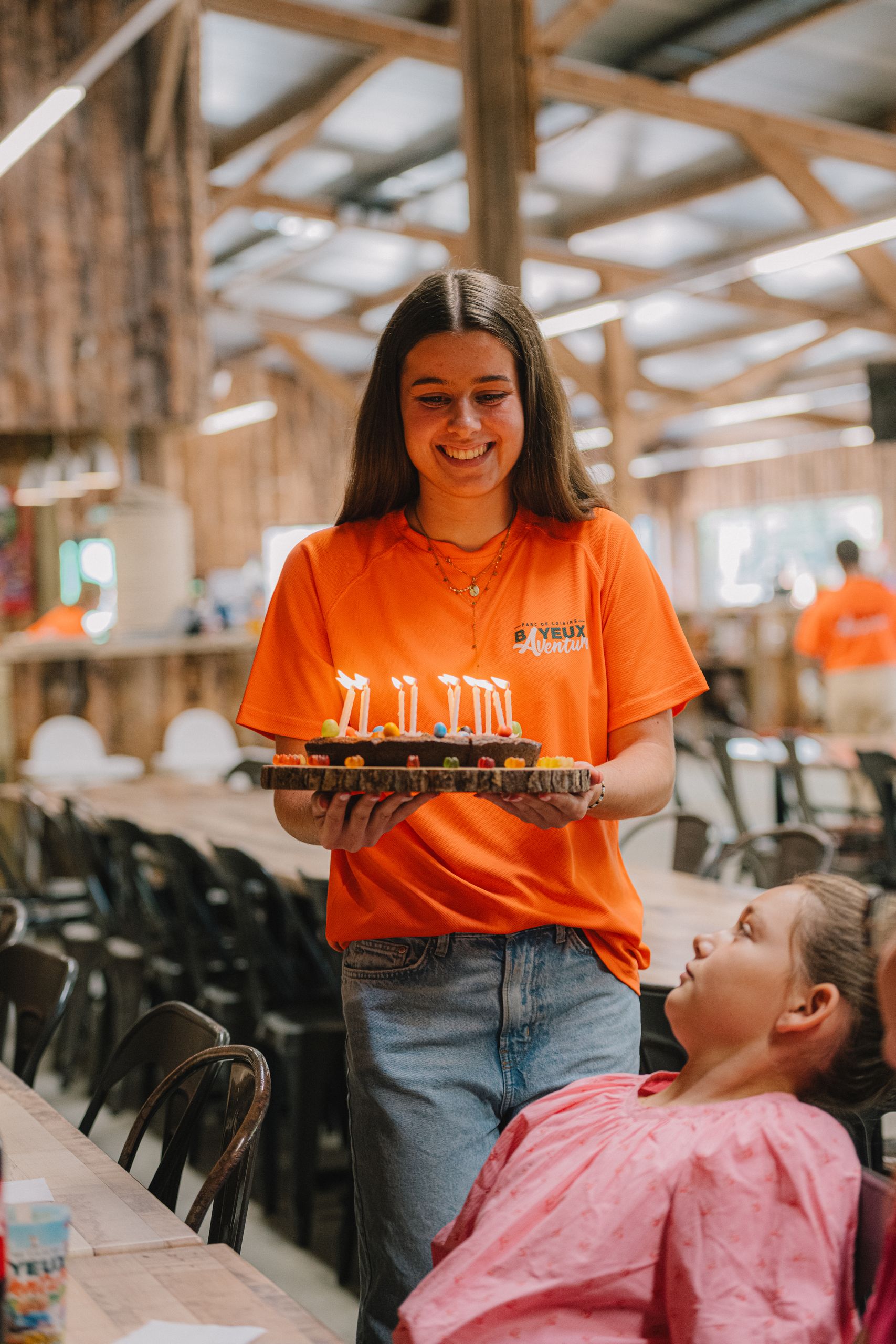 Un membre de l'équipe Bayeux Aventure apporte le gâteau d'anniversaire