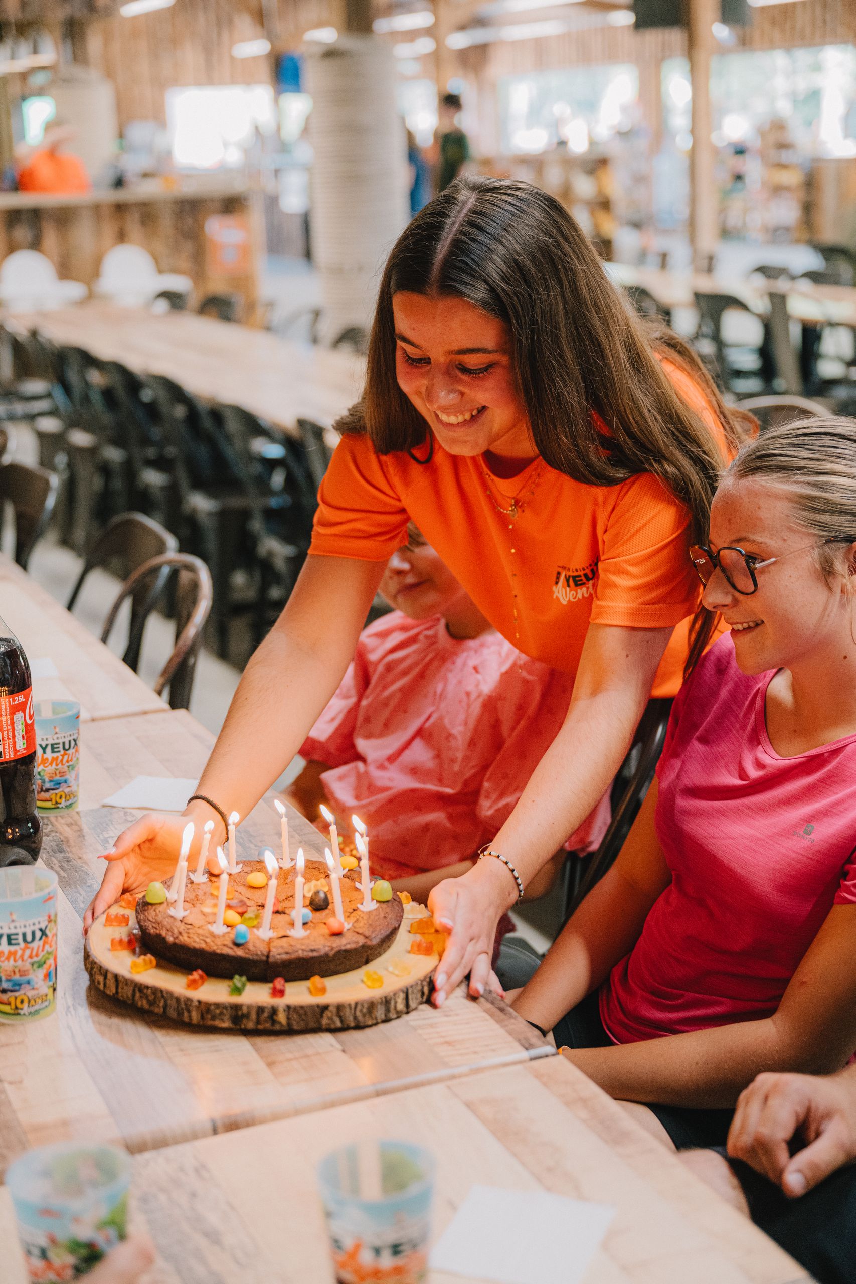 Un membre de l'équipe pose le gâteau d'anniversaire devant les enfants