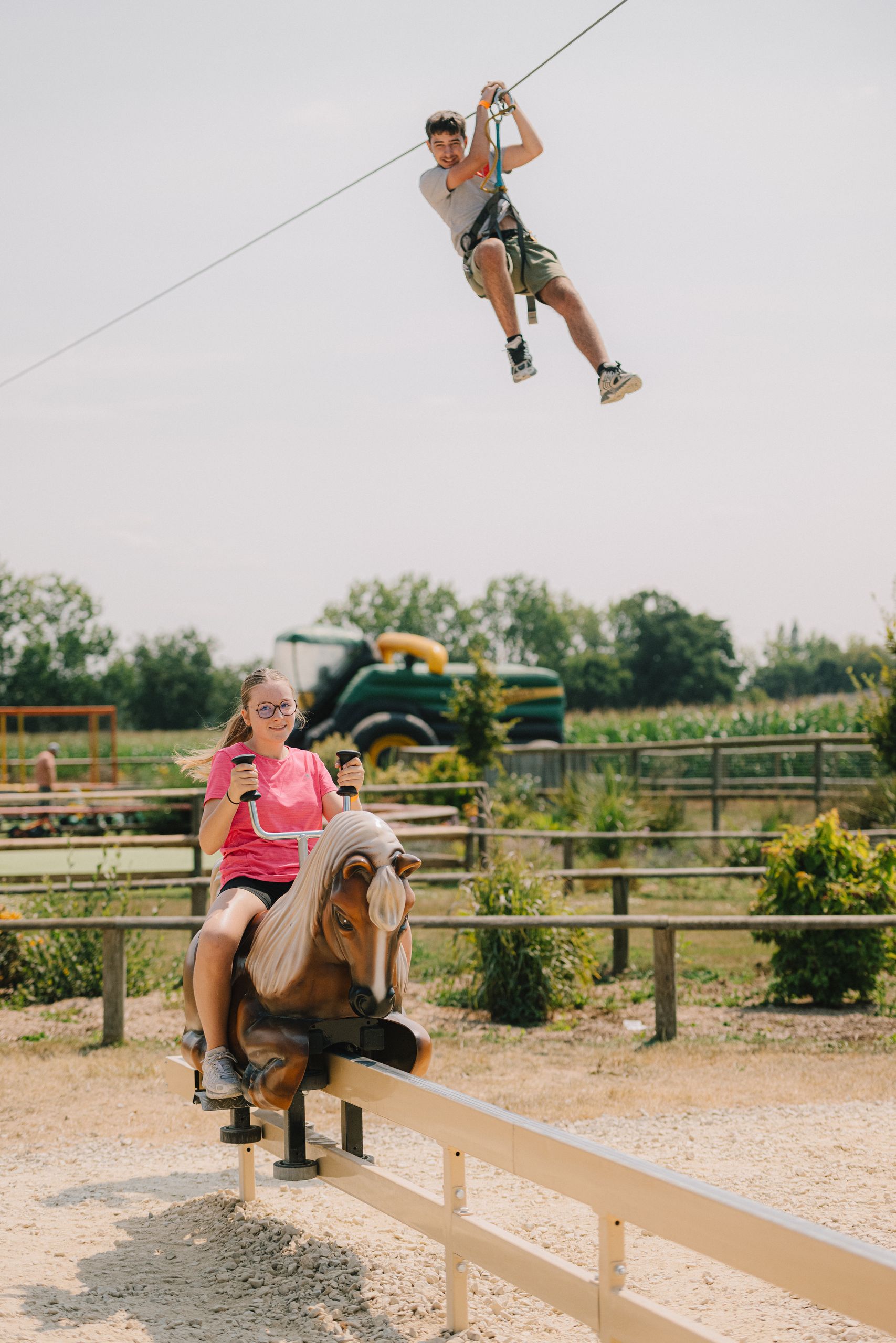 Une cavalière sur un poney mécanique, une tyrolienne au-dessus