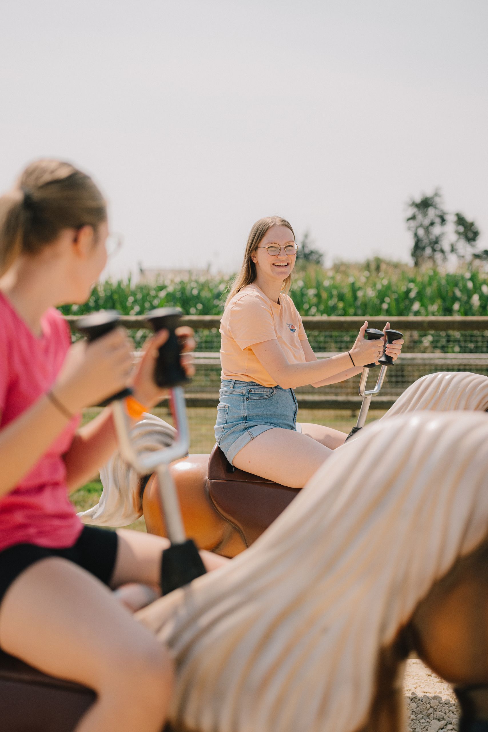 Deux amies côte à côte sur les poneys mécaniques