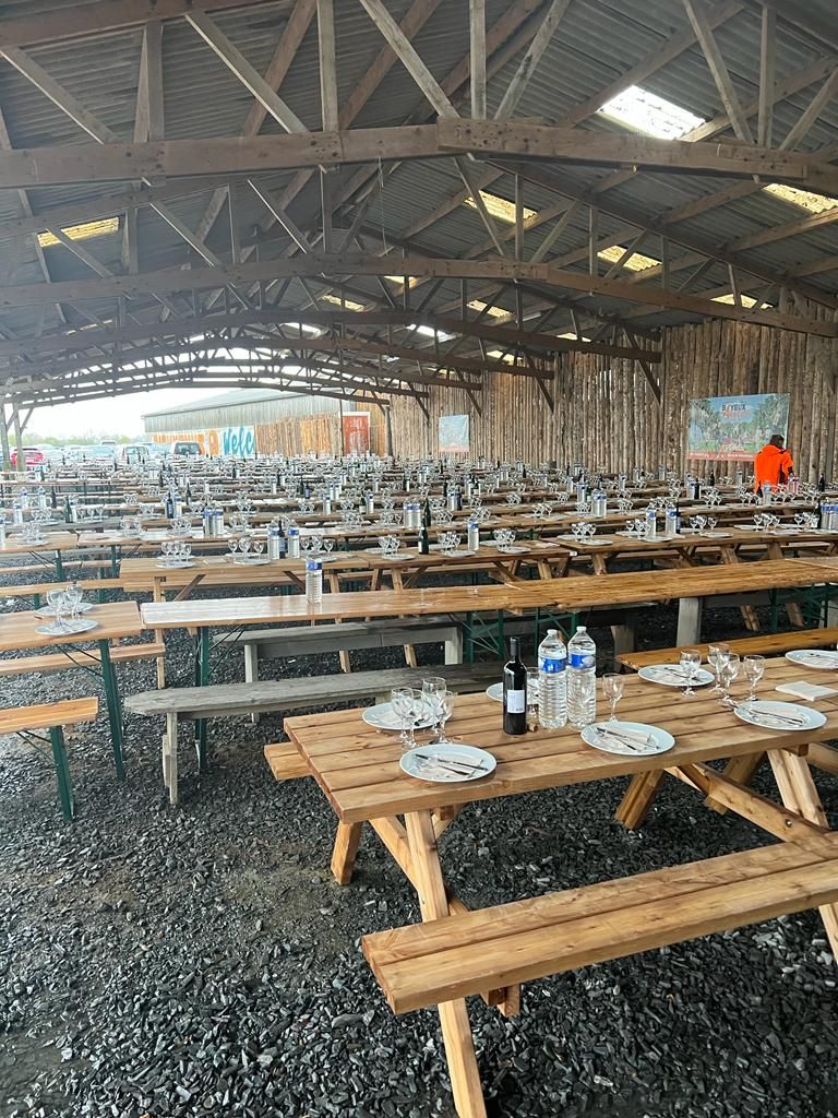 Tables dressées sous le chapiteau pour un repas de groupe