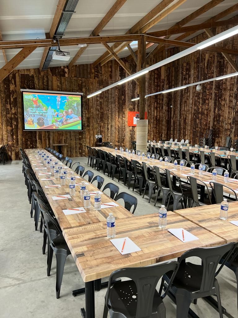 Salle dressée pour une réunion d'entreprise, avec écran de projection