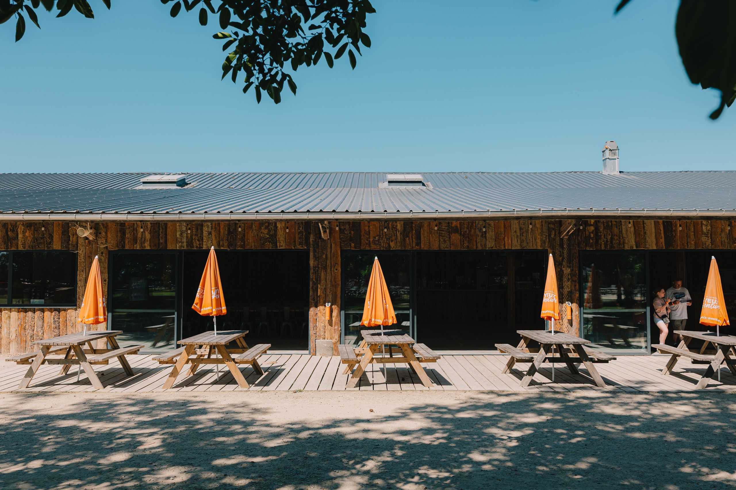 Terrasse devant le bâtiment en bois de Bayeux Aventure